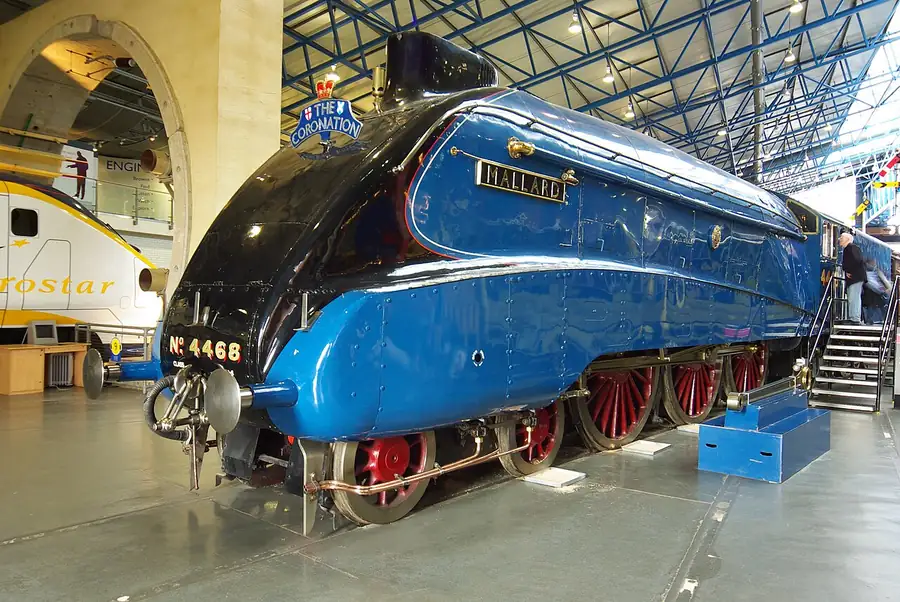 Mallard, a streamlined blue steam locomotive, displayed inside a railway museum